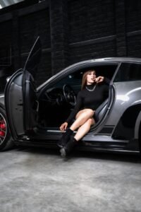 Stylish woman sitting in a sleek sports car, exuding sophistication and elegance.